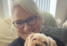 a woman holding a small dog in her arms