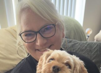 a woman holding a small dog in her arms