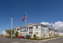 KEY WEST CELEBRATES LONG-AWAITED LOFTS AT BAHAMA VILLAGE a row of houses with a flag flying in the background