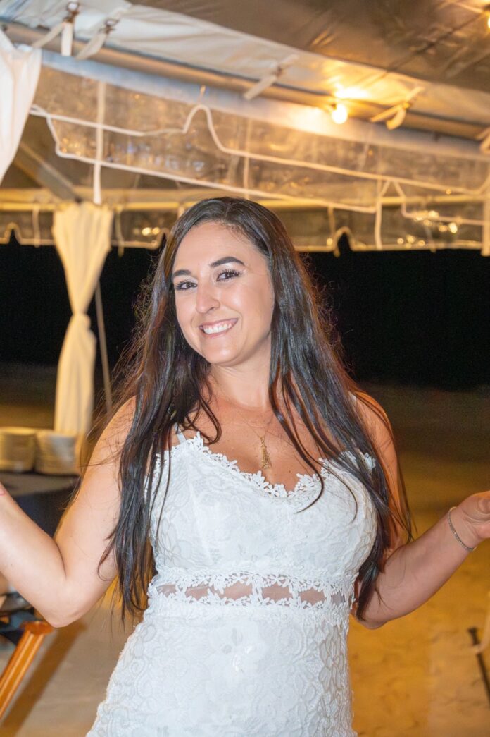 a woman in a white dress standing under a tent