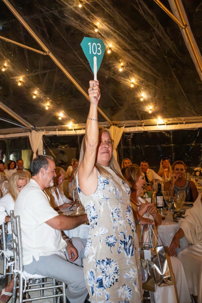 a woman holding up a green sign in front of a crowd