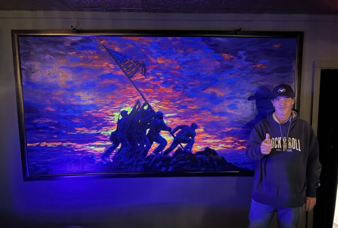 a man standing in front of a painting