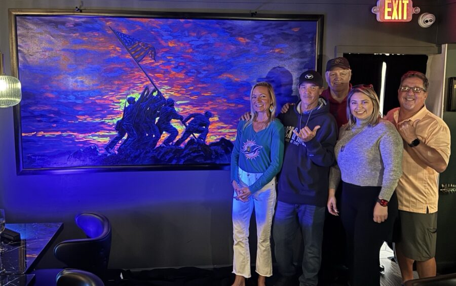 a group of people standing in front of a painting