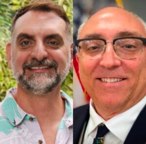 two men in suits and ties smiling for the camera