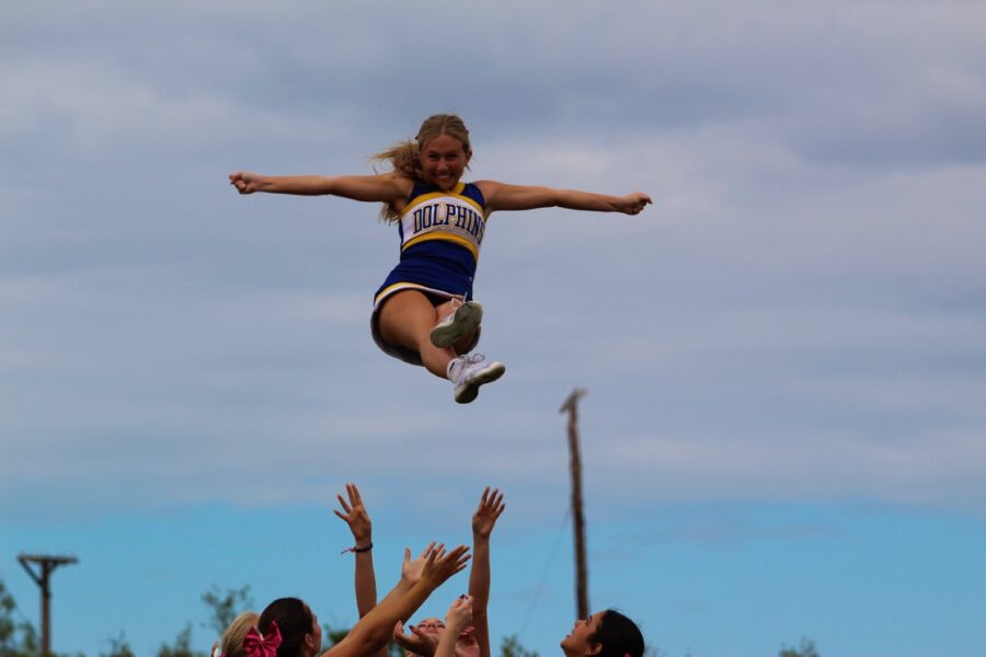 a woman jumping in the air with a ball in front of a group of people