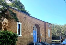 SCHOOL DISTRICT WILL RENOVATE REYNOLDS SCHOOL a car parked in front of a brick building