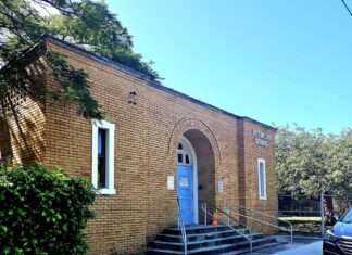SCHOOL DISTRICT WILL RENOVATE REYNOLDS SCHOOL a car parked in front of a brick building