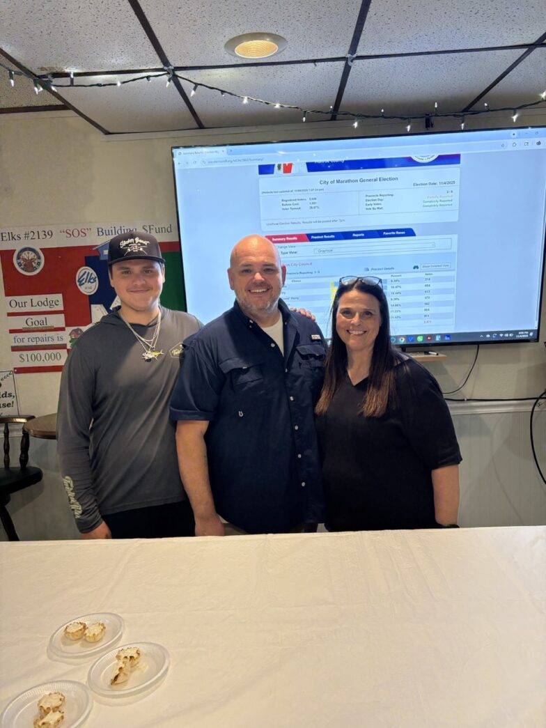 a group of people standing in front of a big screen