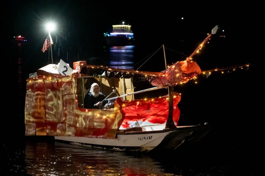 a boat decorated with lights on the water
