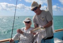 a man and a woman on a boat with a fish
