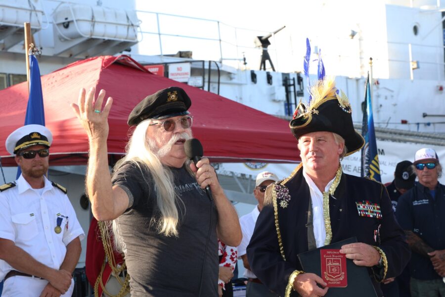 a man in a captain's hat speaking into a microphone