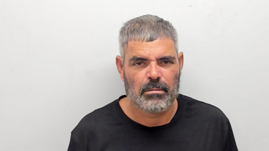 a man in a black shirt is looking at the camera