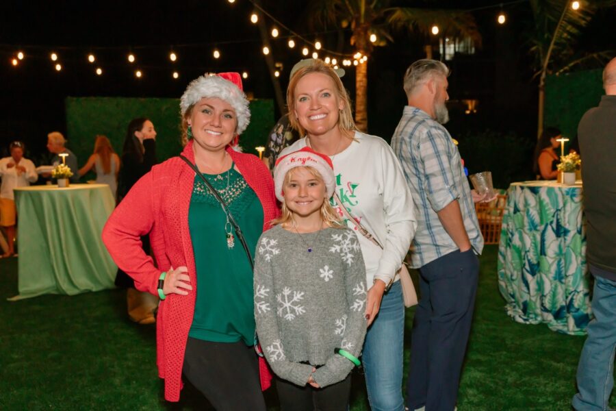 a group of people standing on top of a lush green field
