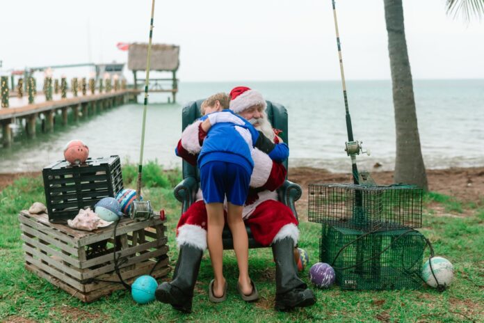a man in a santa suit sitting in a chair next to a child