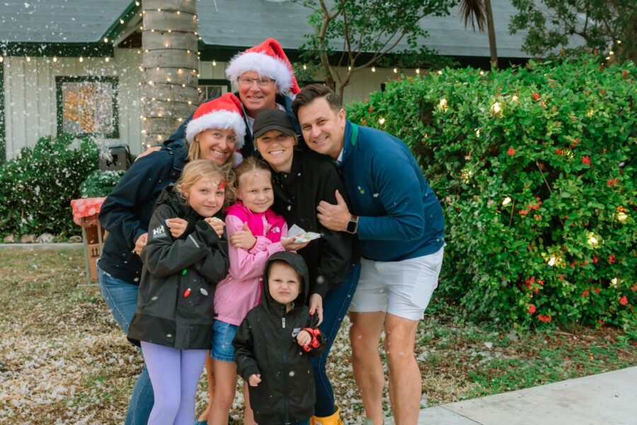 a family poses for a picture in front of a christmas tree