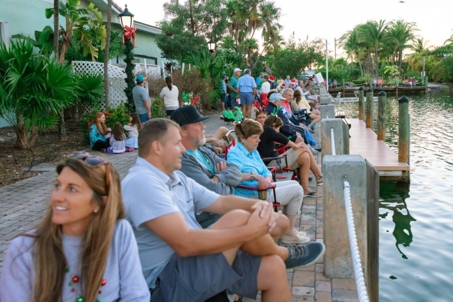 a group of people sitting next to a body of water