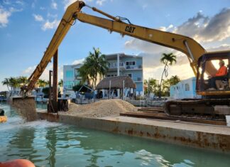 a man is sitting in the water near a construction site