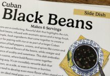 a recipe book on a wooden table with a picture of a bowl of black beans