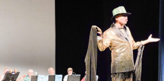 a man standing on a stage with a hat on