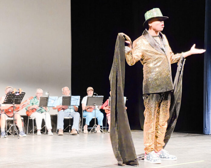 Bob Bunz Spencer croons for the crowd a man standing on a stage with a hat on