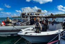a group of people standing on a boat in the water