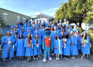 a group of people in blue graduation gowns posing for a picture