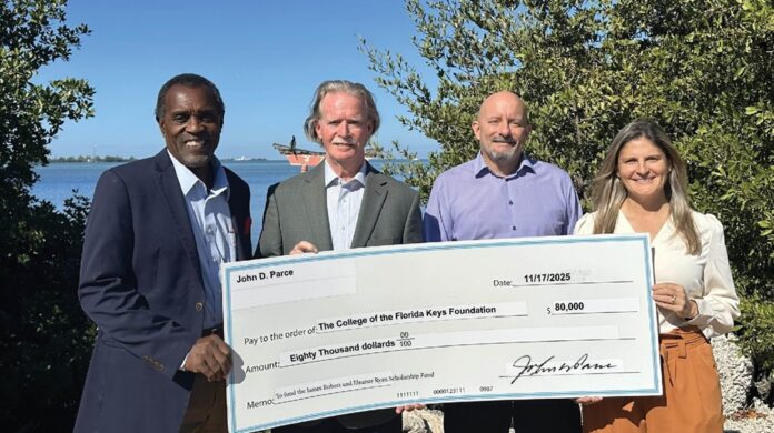 a group of people standing next to each other holding a large check