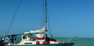 a small sailboat in the middle of the ocean