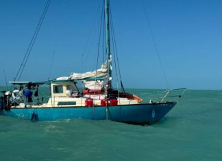 a small sailboat in the middle of the ocean