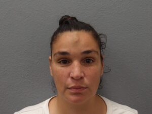 a woman in a white shirt is looking at the camera