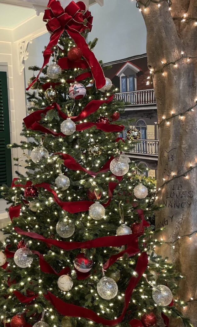 a christmas tree with red ribbon and ornaments