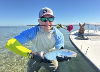 FLORIDA KEYS FISH REPORT: COLD FRONTS BRING HUNGRY BONEFISH a man holding a fish while standing on a boat