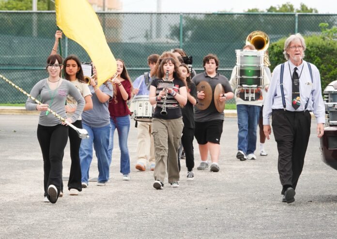 Coral Shores band 1 Large a group of people walking down a street