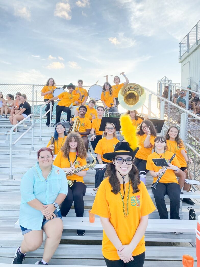 a group of people sitting on bleachers with musical instruments