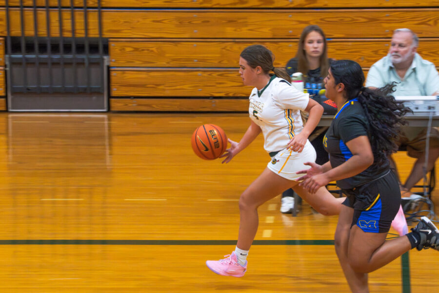 a group of young women playing a game of basketball
