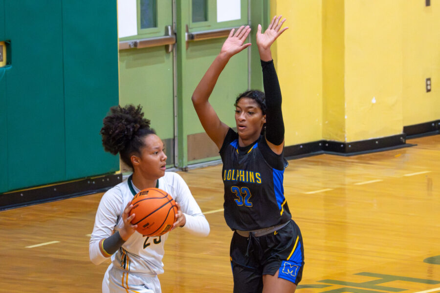two girls playing basketball in a gym