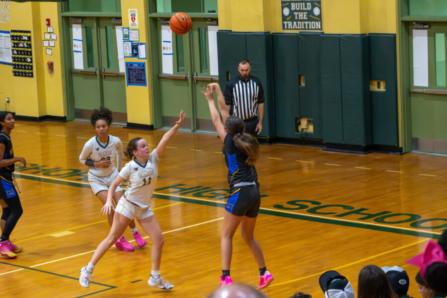a group of young women playing a game of basketball