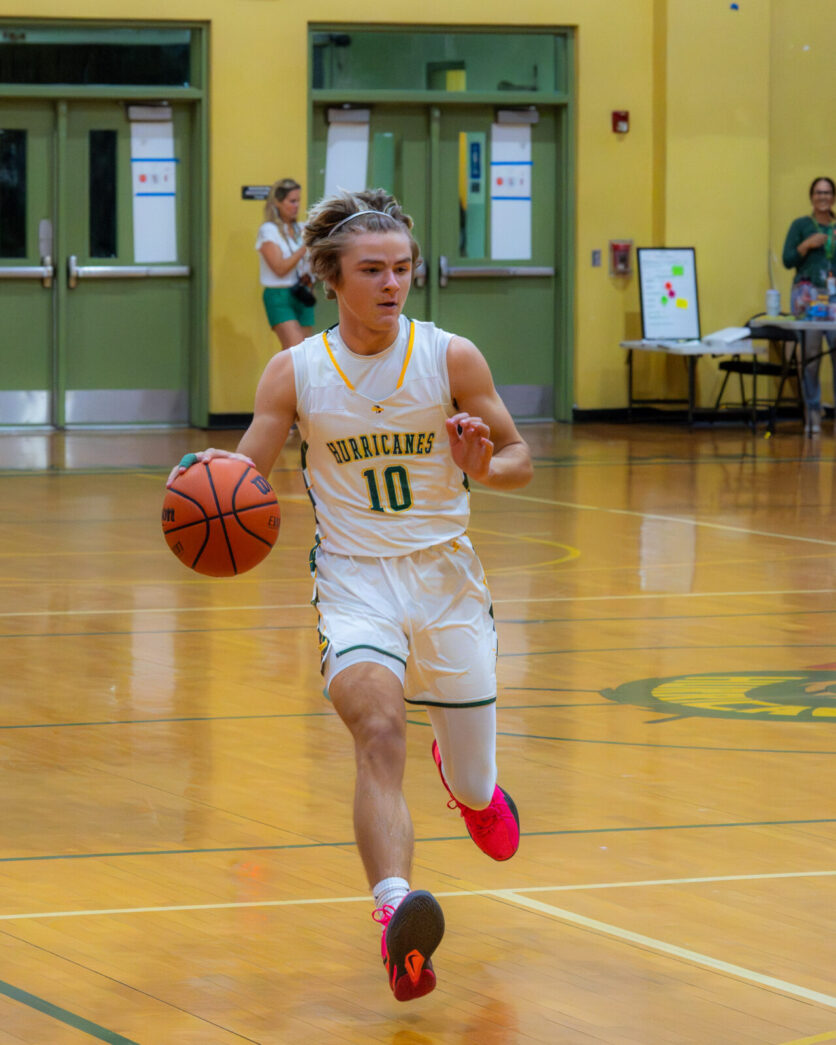 a basketball player dribbles the ball down the court