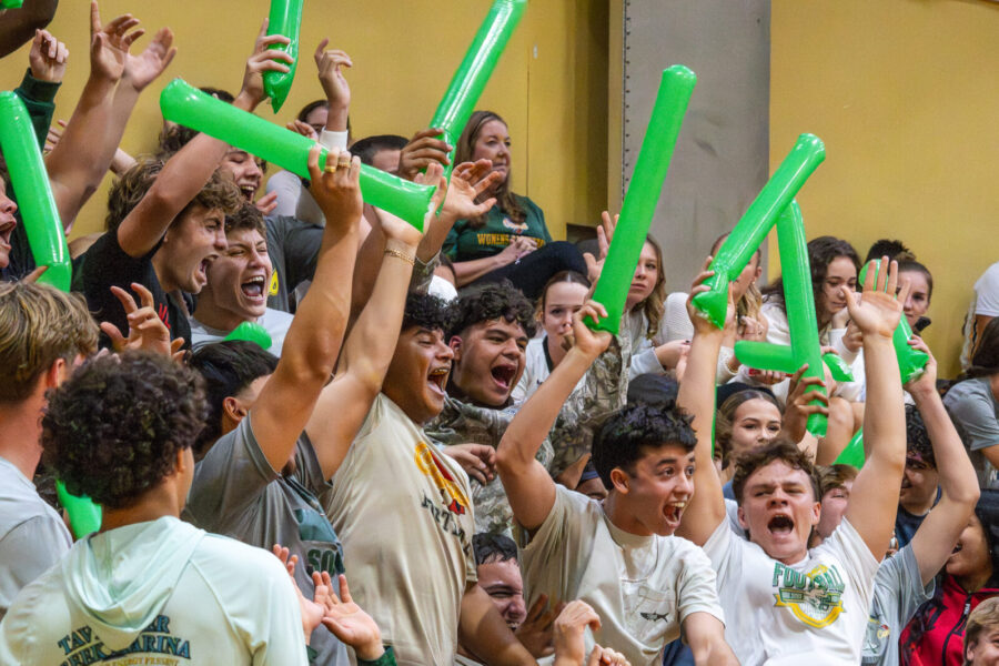 a group of people holding up green balloons