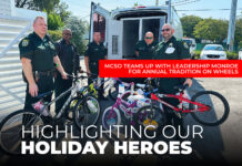 FULL-CIRCLE GIVING: MCSO TEAMS UP WITH LEADERSHIP MONROE FOR ANNUAL TRADITION ON WHEELS a group of men standing next to each other