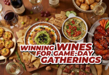 a wooden table topped with plates of food and wine