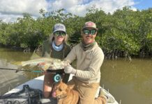 a man and a woman on a boat with a dog