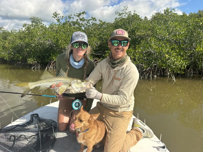 Hastings with snook a man and a woman on a boat with a dog