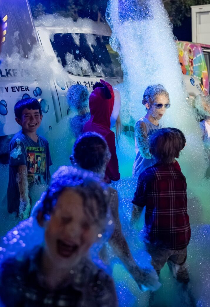 a group of children playing in a water fountain