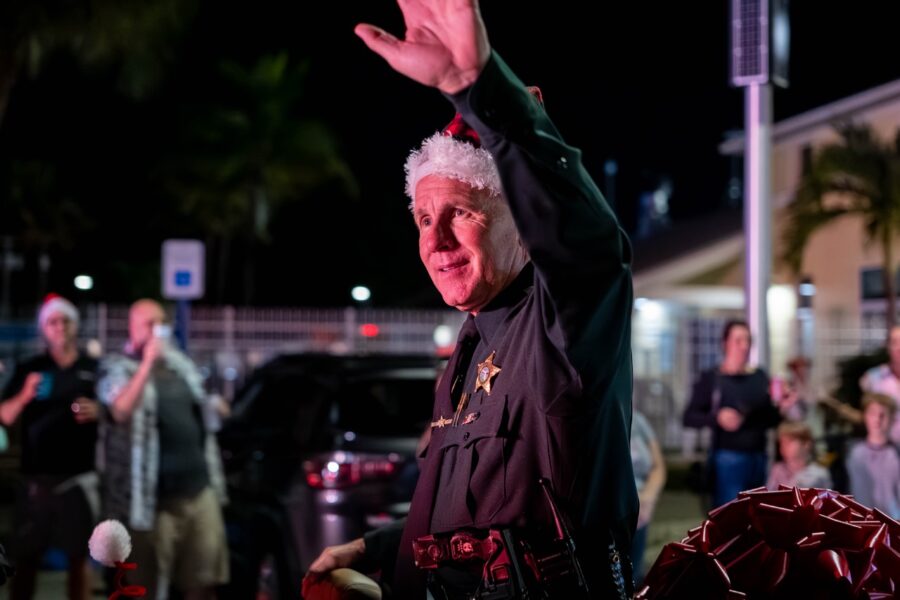 a man in a police uniform waves to the crowd