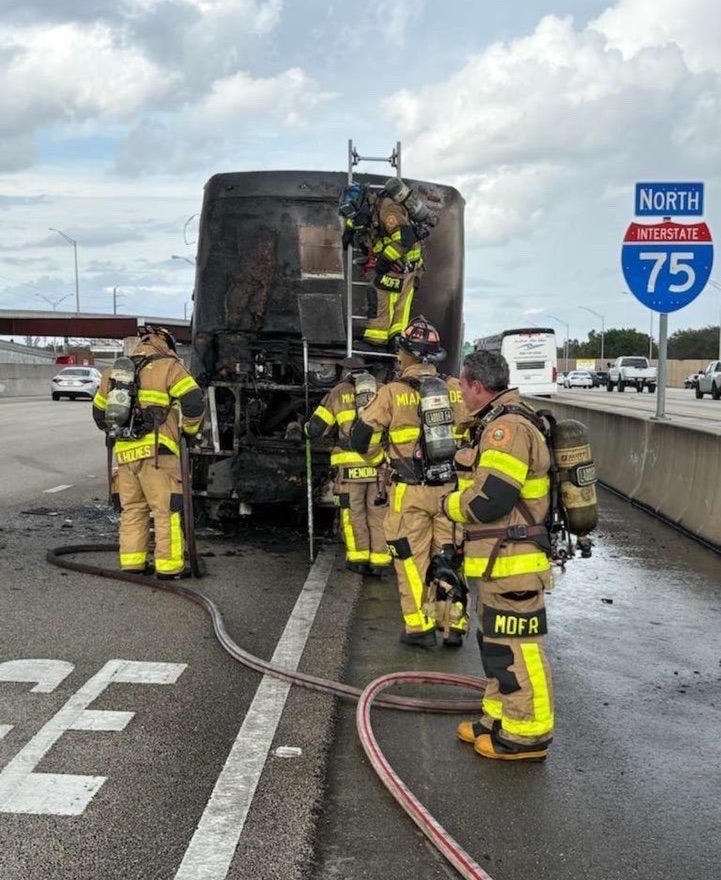 a group of firefighters standing next to a fire truck