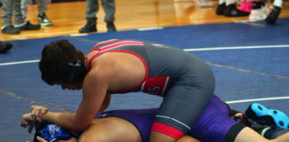 a wrestling player is on the ground with his opponent