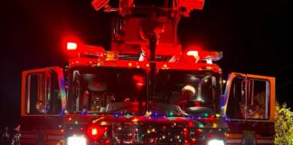 a fire truck with lights on driving down a road