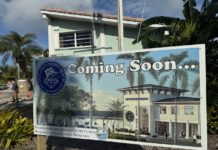 KEY COLONY BEACH BREAKS GROUND ON NEW CITY HALL a sign for a building with palm trees in the background