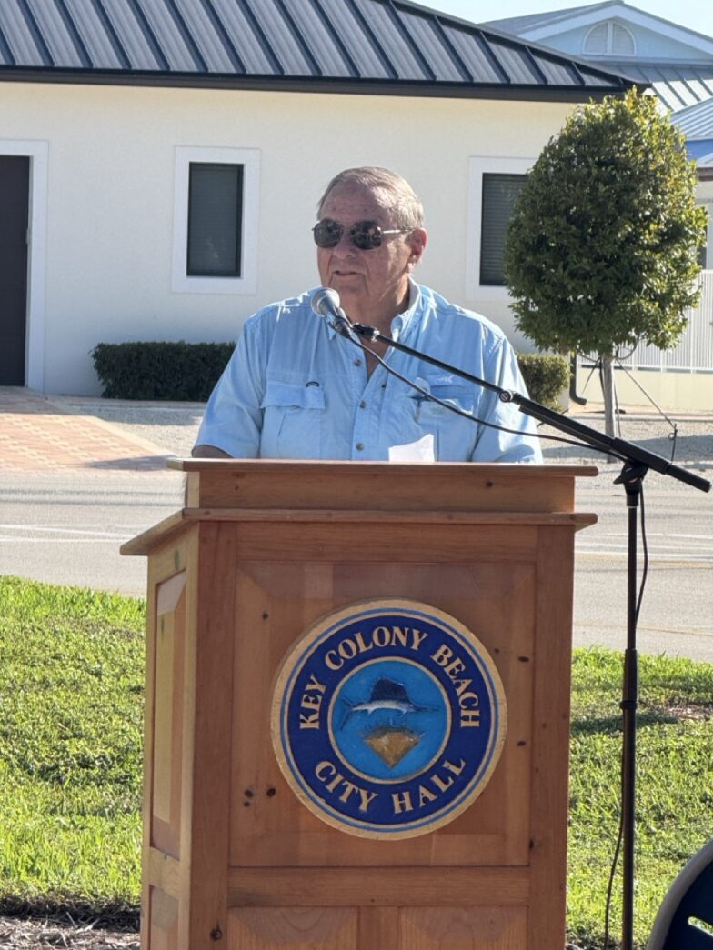 a man standing at a podium in front of a building